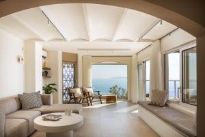 a living room with a couch and a table at In Blue Villa, Sea View Reverie with a Secluded Beach by etouri in Heraklio Town
