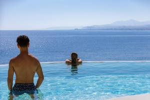 a man and a woman in the water in a swimming pool at In Blue Villa, Sea View Reverie with a Secluded Beach by etouri in Heraklio Town +72 photos