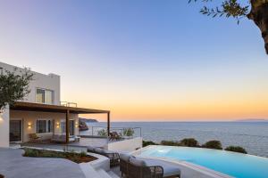 a villa with a swimming pool in front of the ocean at In Blue Villa, Sea View Reverie with a Secluded Beach by etouri in Heraklio Town