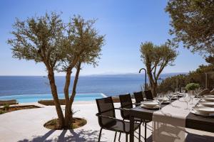 a dining table with a view of the ocean at In Blue Villa, Sea View Reverie with a Secluded Beach by etouri in Heraklio Town