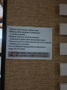 a sign on the side of a brick wall at Adnan Company Hostel in Baku
