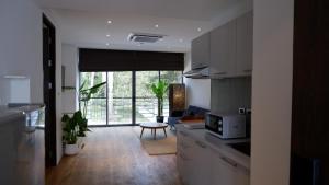 a kitchen with a microwave and a living room at The Lush Apartments & Suites in Pilai Beach