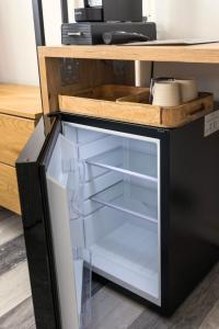 a refrigerator with its door open under a desk at EssenzApartment Hof, 24h Checkin, Parkplatz, WLan300Mbit in Hof