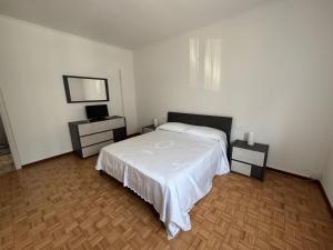 a bedroom with a white bed and two night stands at Casa Luna in Mandello del Lario