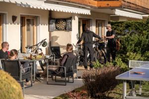 a group of people sitting at tables outside a house at Ride Inn Verbier - B&B - private small twin room, shared bathrooms in Verbier