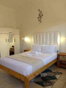 Un dormitorio con una cama grande con sábanas y almohadas blancas. en Onguti Guesthouse & Spa, en Windhoek