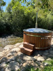 a wooden hot tub sitting on a pile of rocks at Apartmány Starý mlyn in Habovka