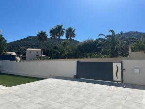 una recinzione bianca con un cancello con un cartello sopra di Villa neuve avec piscine 3 chambres 140 m2 a Calvi