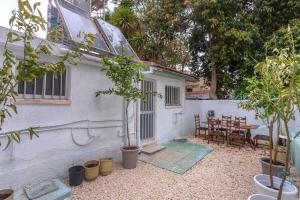 a small white house with a table and chairs at Two Bedroom Garden Cottage in Quiet Street in Limassol
