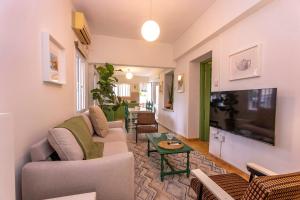 a living room with a couch and a tv at Two Bedroom Garden Cottage in Quiet Street in Limassol