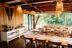 a large dining room with tables and chairs at By The Lake - A Frame in Căciulaţi