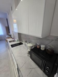 a kitchen with a black microwave and a counter at Apartament Centrum in Gdynia
