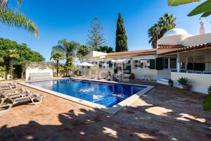 a swimming pool in front of a house at Quinta do Vale Formoso in Armação de Pêra