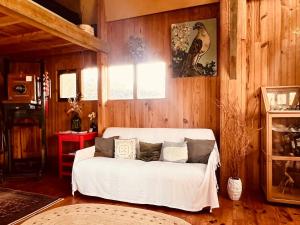 Sofá blanco en una habitación con paredes de madera en Grange atypique en pleine nature, en La Gaillarde