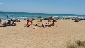 un grupo de personas en una playa con el océano en Residence Giglio, en Torre Pali