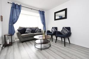a living room with a couch and chairs and a table at Lovely 3-Bed in Scenic Aberdare! in Aberdare +48 photos