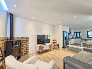 een woonkamer met een open haard, een bank en een tv bij V3 Atlantida Farm in Quelfes