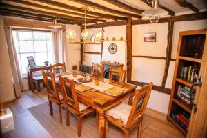 a dining room with a wooden table and chairs at Ye Olde Cottage in Crawley