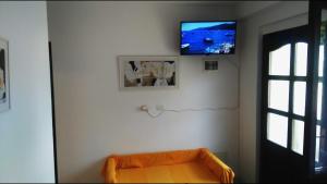 a flat screen tv on a white wall with a couch at Apartments Kalac in Labin