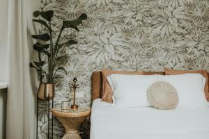 a bedroom with a bed with a plant on a wall at ForRest Suites in Ermelo