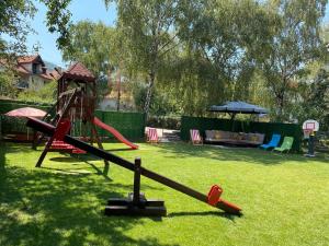 a playground with a slide in a yard at Apartmani Milojić in Soko Banja