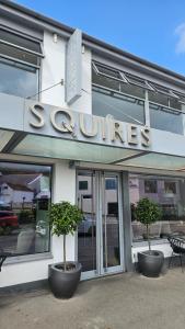 ein Geschäft mit zwei Topfbäumen davor in der Unterkunft Sleep Squires in Braunton