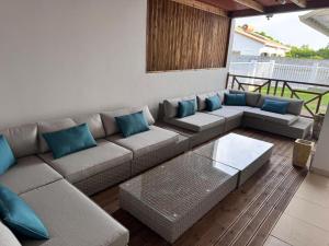 a living room with a couch and blue pillows at Villa Rose-May in Saint-Pierre +4 photos
