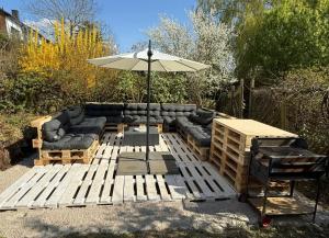 eine Terrasse mit Sofa und Sonnenschirm in der Unterkunft Welliebeach Große Ferienwohnung in Hameln
