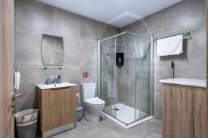 a bathroom with a shower and a toilet and a sink at Invictus 2-Bedroom Apartment in Larnaca +9 photos