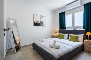 a bedroom with a bed with green curtains and a mirror at Invictus 2-Bedroom Apartment in Larnaca
