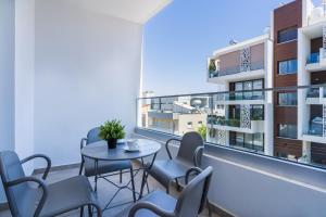 a balcony with a table and chairs and a building at Invictus 2-Bedroom Apartment in Larnaca