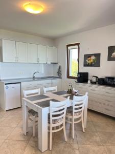 a kitchen with a table and white cabinets and a table and chairs at Panorama Pearl Sea View in Balchik