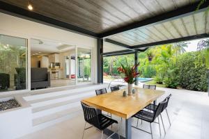 ein Esszimmer im Freien mit einem Holztisch und Stühlen in der Unterkunft Sunova Pool Villa - Koh Chang in Ko Chang