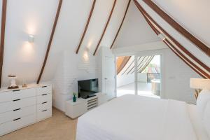 une chambre blanche avec un lit et une télévision dans l'établissement Sunova Pool Villa - Koh Chang, à Ko Chang