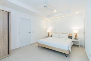 ein weißes Schlafzimmer mit einem weißen Bett und zwei Lampen in der Unterkunft Sunova Pool Villa - Koh Chang in Ko Chang