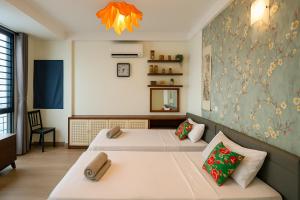 a bedroom with two beds and a mirror at Flower Homestay-Grand opening-VIP Homestay Local-Indochic-4Bedrooms in Hanoi