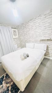 a bedroom with a large white bed with towels on it at One Bedroom Apartment Barking in Barking