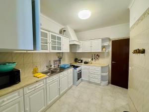 a kitchen with white cabinets and a sink at Casa de Sintra in Sintra