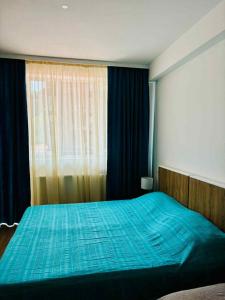 a bedroom with a blue bed and a window at tribu apart hotel in Bakuriani +5 photos