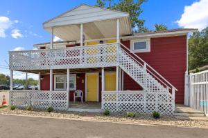 a red house with a white porch and a yellow door at Dave's Last Resort Poolside-Relaxing Cabin 3 Hotel Room in Monticello