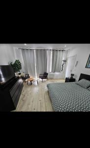 a bedroom with a bed and a couch and a table at Studio cozy et charmant in Brussels +3 photos