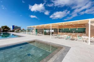 a building with a pool and a patio with tables and chairs at Sol Fuerteventura Jandia - All Suites in Morro del Jable +56 photos