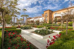 a garden in front of a building with flowers at Barceló Isla Canela in Isla Canela