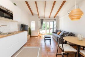a kitchen and living room with a couch and a table at Your new corner in Menorca in Arenal d'en Castell