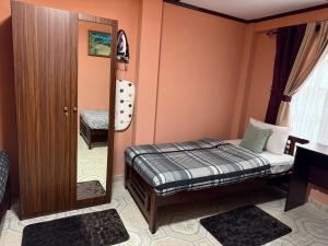 a small bedroom with a bed and a mirror at RUU Holiday Home in Nuwara Eliya