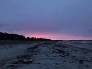 a dirt road on the beach at sunset at 4 person holiday home in Knebel in Knebel