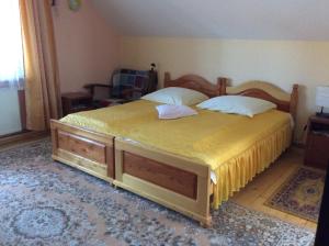 um quarto com uma cama grande e 2 almofadas em Casa Andrada & Ilinca em Gura Humorului