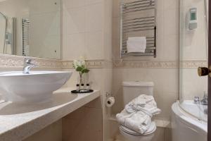 a white bathroom with a sink and a toilet at Passage House Hotel in Newton Abbot