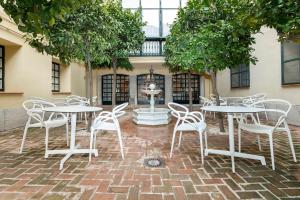 a group of tables and chairs in front of a building at LoopINN Granada in Granada