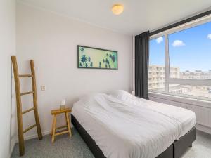 a bedroom with a bed and a ladder and a window at Apartment near North Sea and Lighthouse in Egmond aan Zee